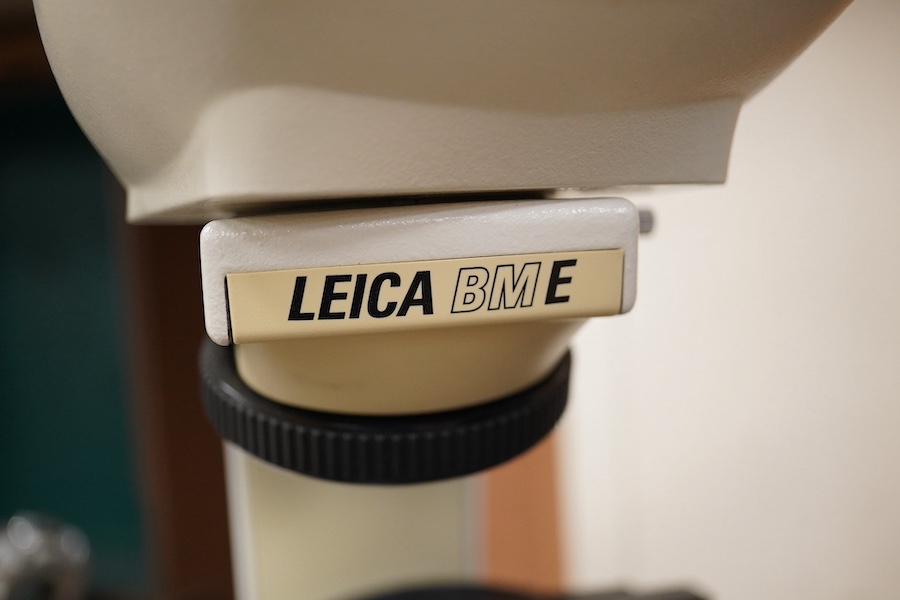 Three mid twentieth century microscopes; a Leica BM E binocular microscope, a Watson Microsystem 70 and a C. Baker, London, No.41840. Condition - fair.